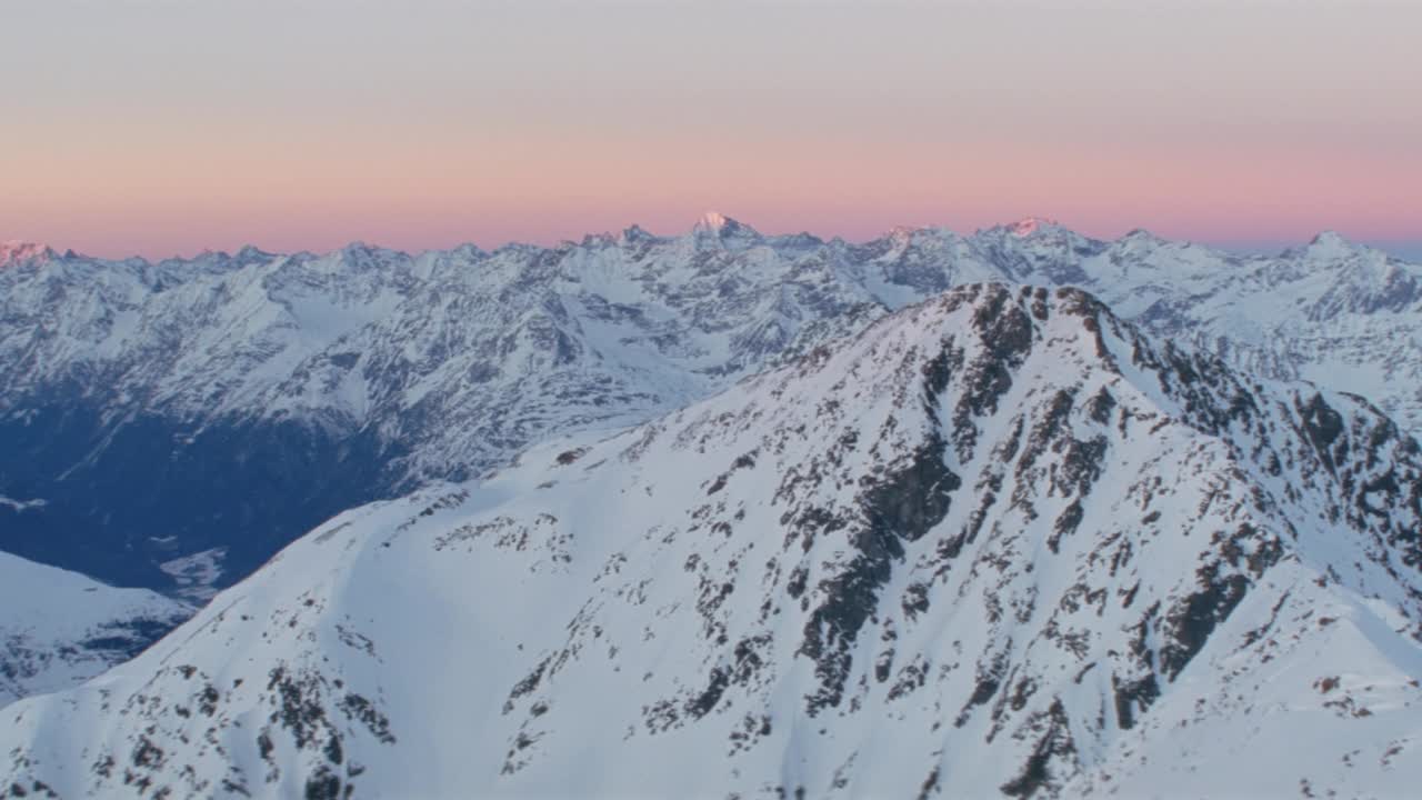 日出时雪山山峰和山脊的鸟瞰图视频素材