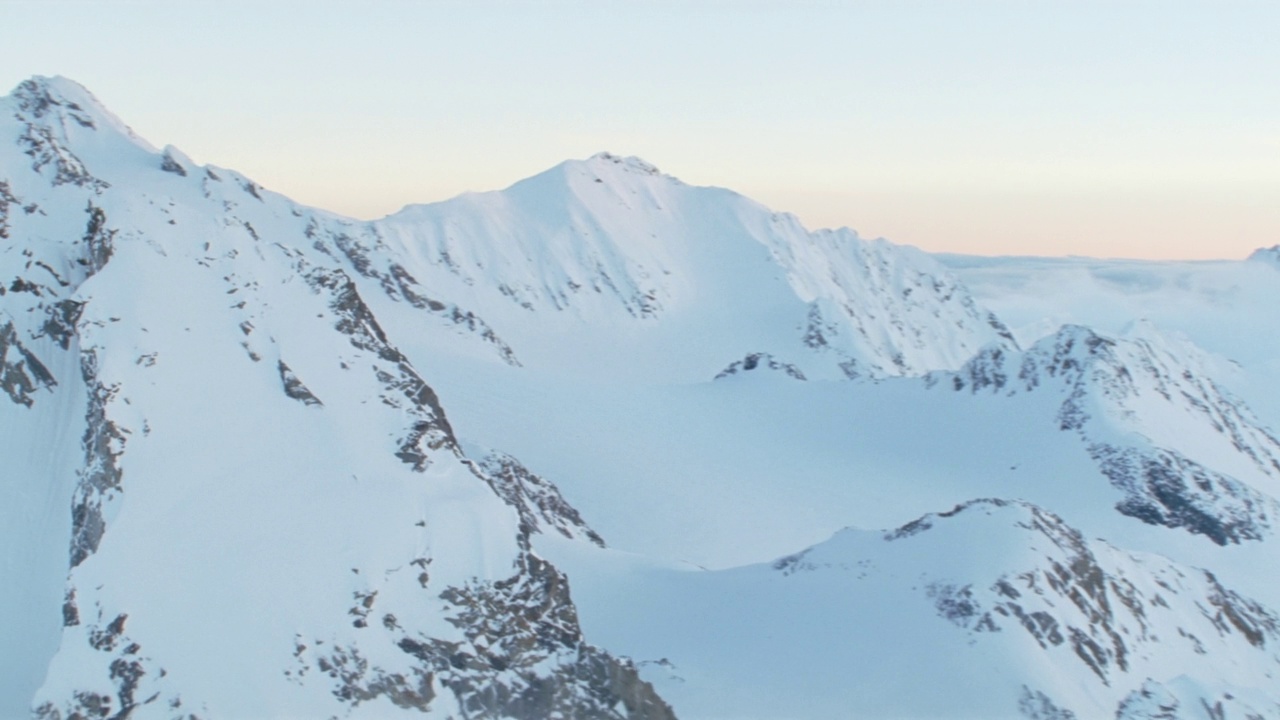 天空映衬下的雪峰和山谷的鸟瞰图视频素材