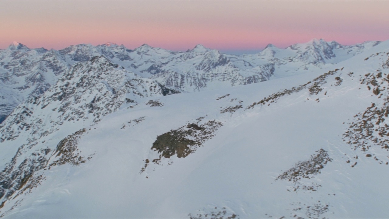 日出时雪山山脊映衬天空的鸟瞰图视频素材