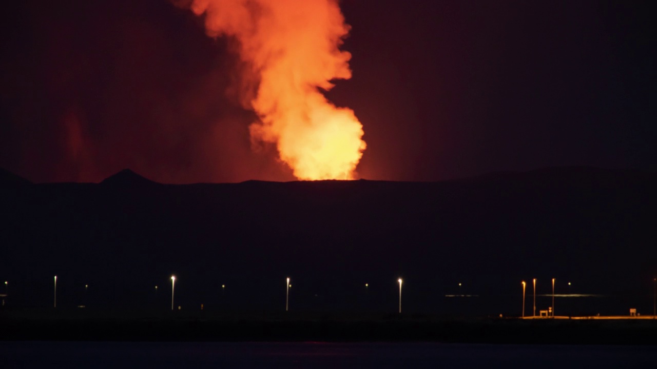 火山在冰岛雷克雅未克夜间的交通上空喷发视频素材