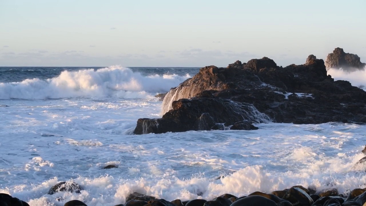 日落时海浪拍打着岩石视频素材