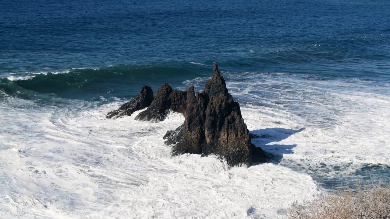 阳光明媚的日子，海浪拍打着海岸。特内里费岛的贝尼霍海滩。(普拉德Benijo)。视频素材