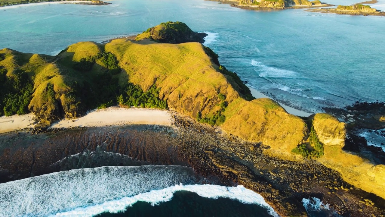 空中环绕拍摄龙目岛，著名的Bukit Merese山和沙滩和海浪。Lombok,印度尼西亚。视频下载