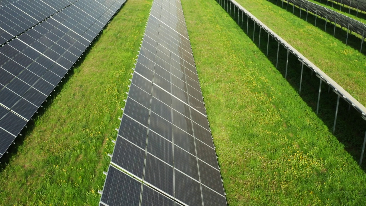 现代的太阳能电池板建在农村田野上郁郁葱葱的草地上视频素材