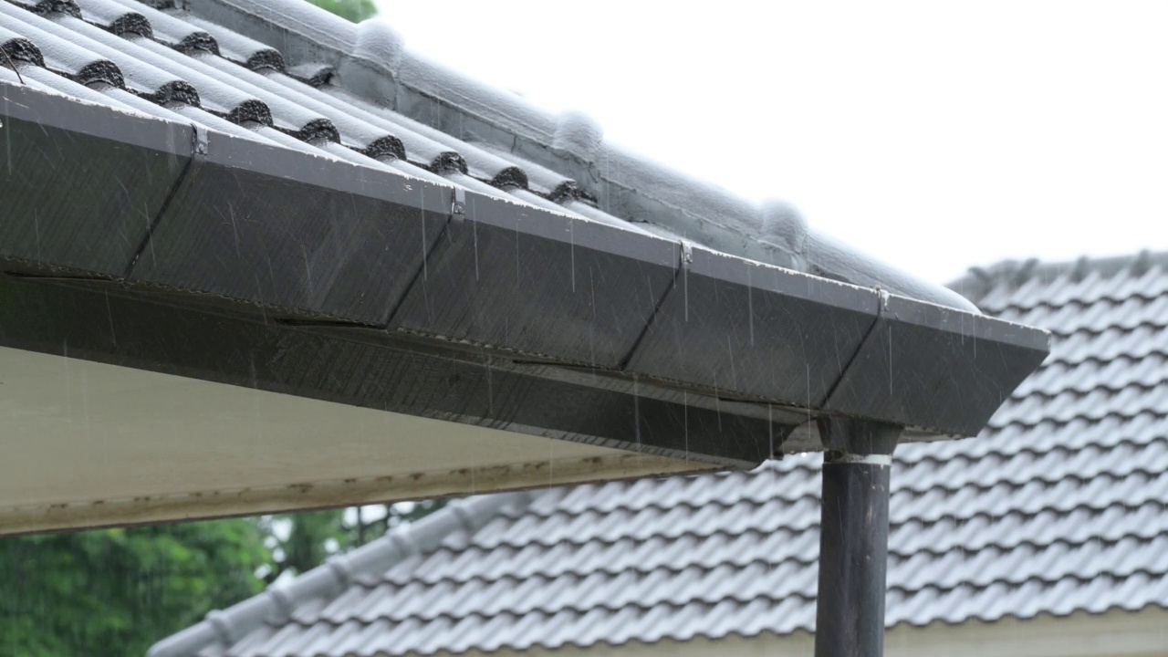 雨季，大雨滂沱，雨水倾泻在天沟屋顶的房子上视频素材