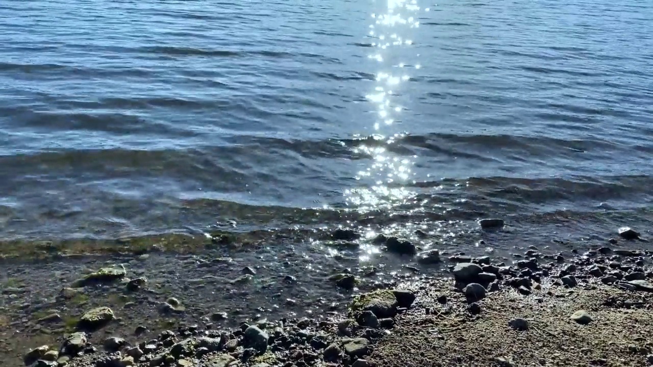 阳光明媚的海滩波浪海边海岸波浪流阳光闪闪发光的太阳反射湖水多风的海洋冲浪视频素材