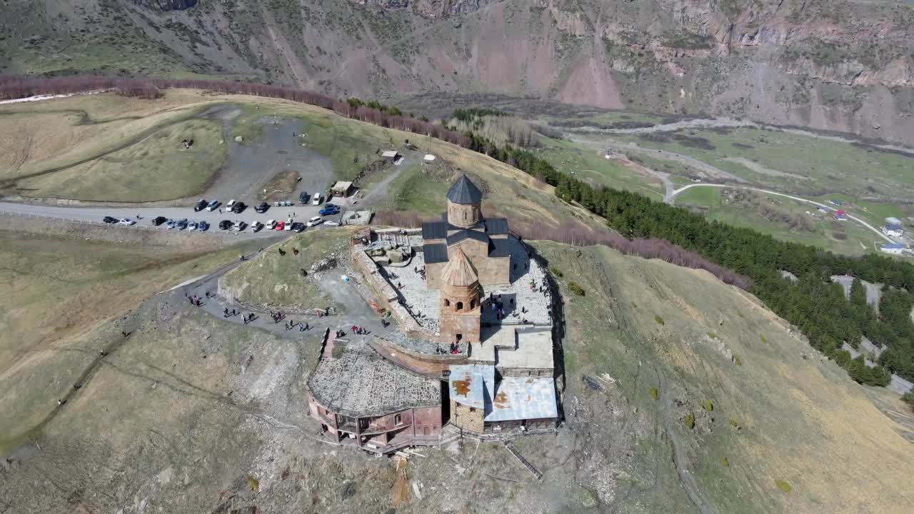 摄影无人机在乔治亚州Stepantsminda村附近的圣三一教堂(Gergeti Trinity Church)上空飞行视频素材