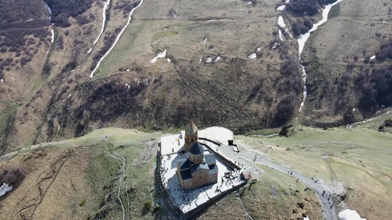 摄影无人机在斯stepsminda村附近盘旋，降落到圣三一教堂(Gergeti Trinity Church)视频素材