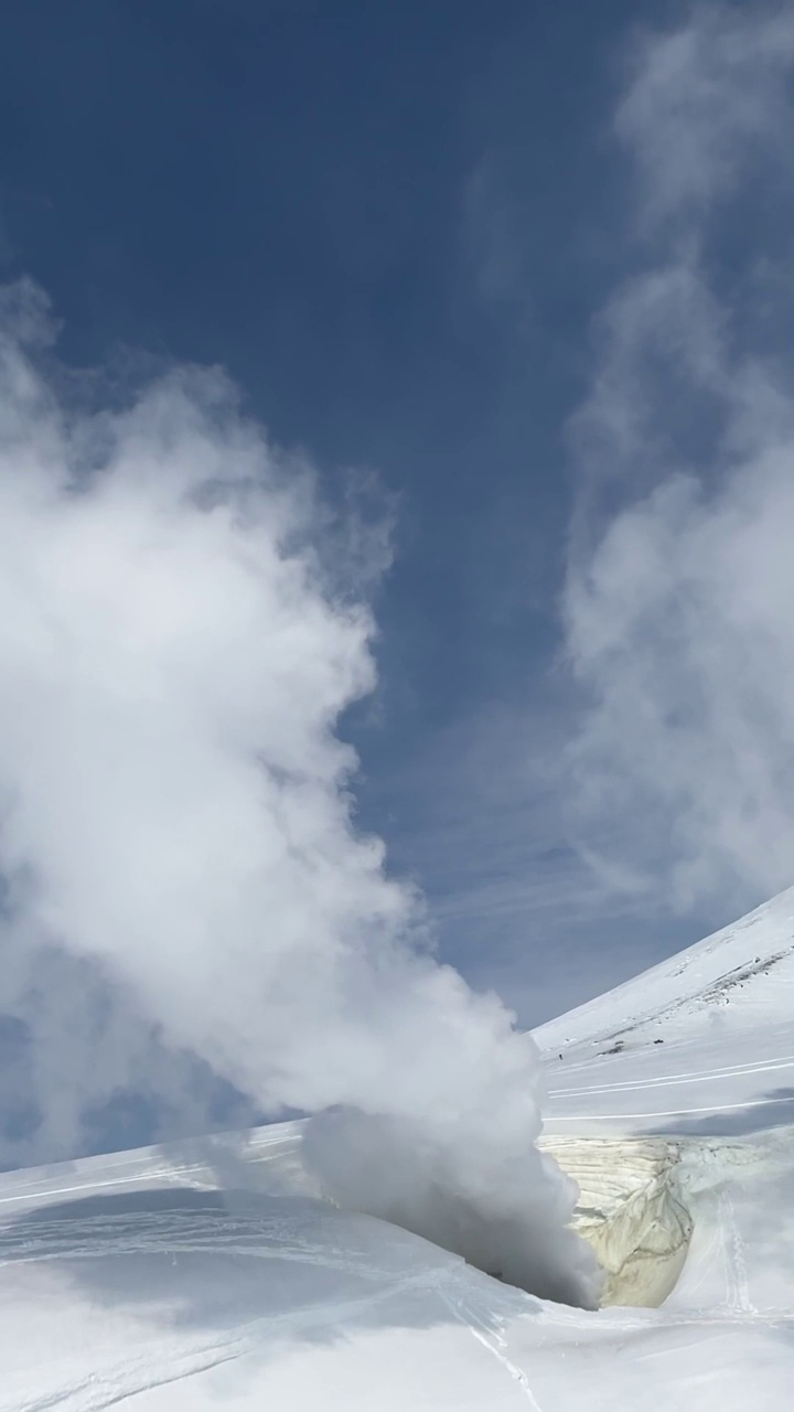 白雪皑皑的山腰上，蒸汽从火山口上升视频素材