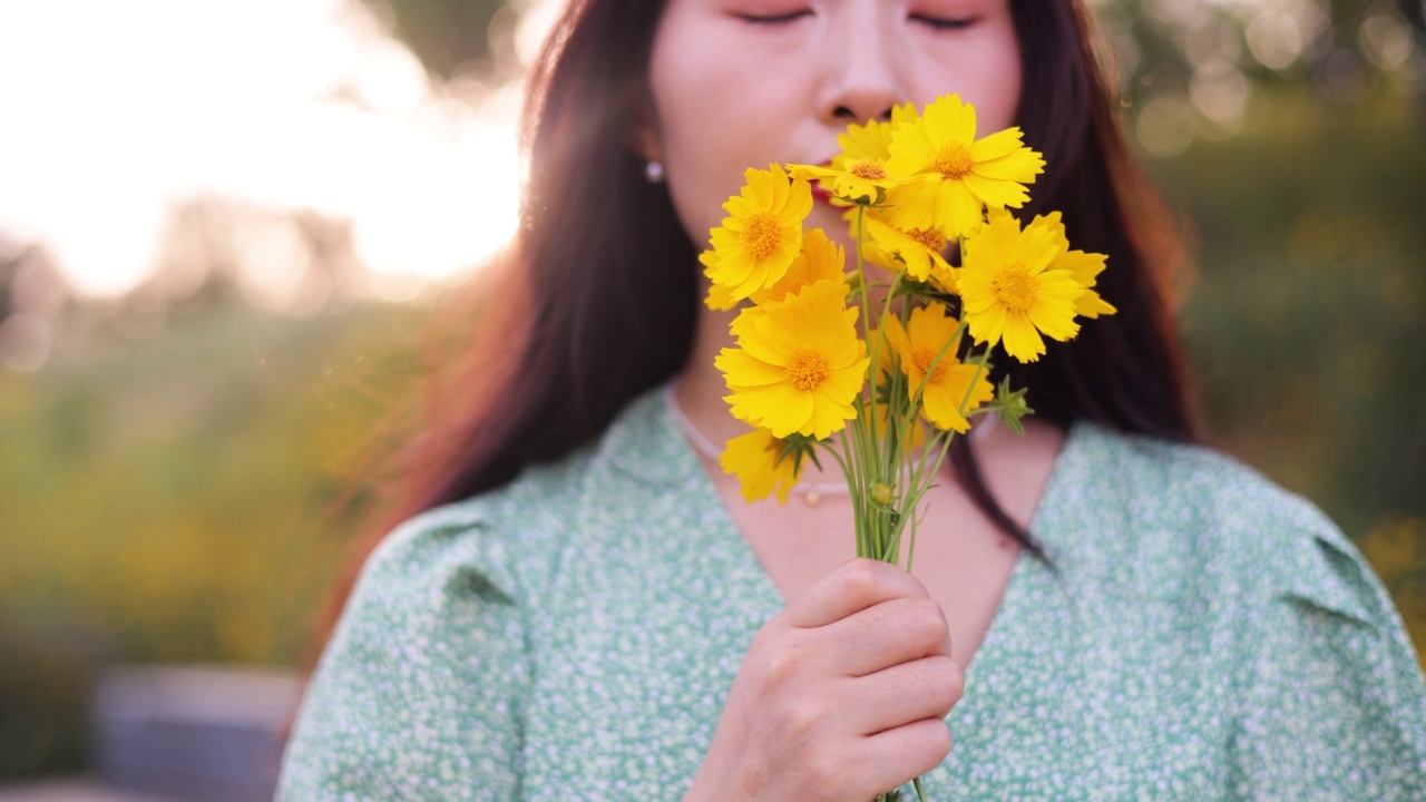 女人手里拿着黄色的花视频素材