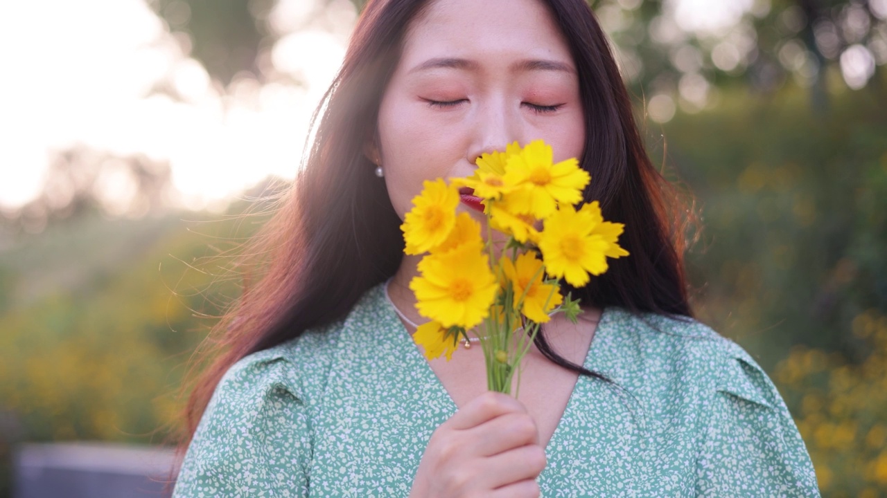 女人手里拿着黄色的花视频素材