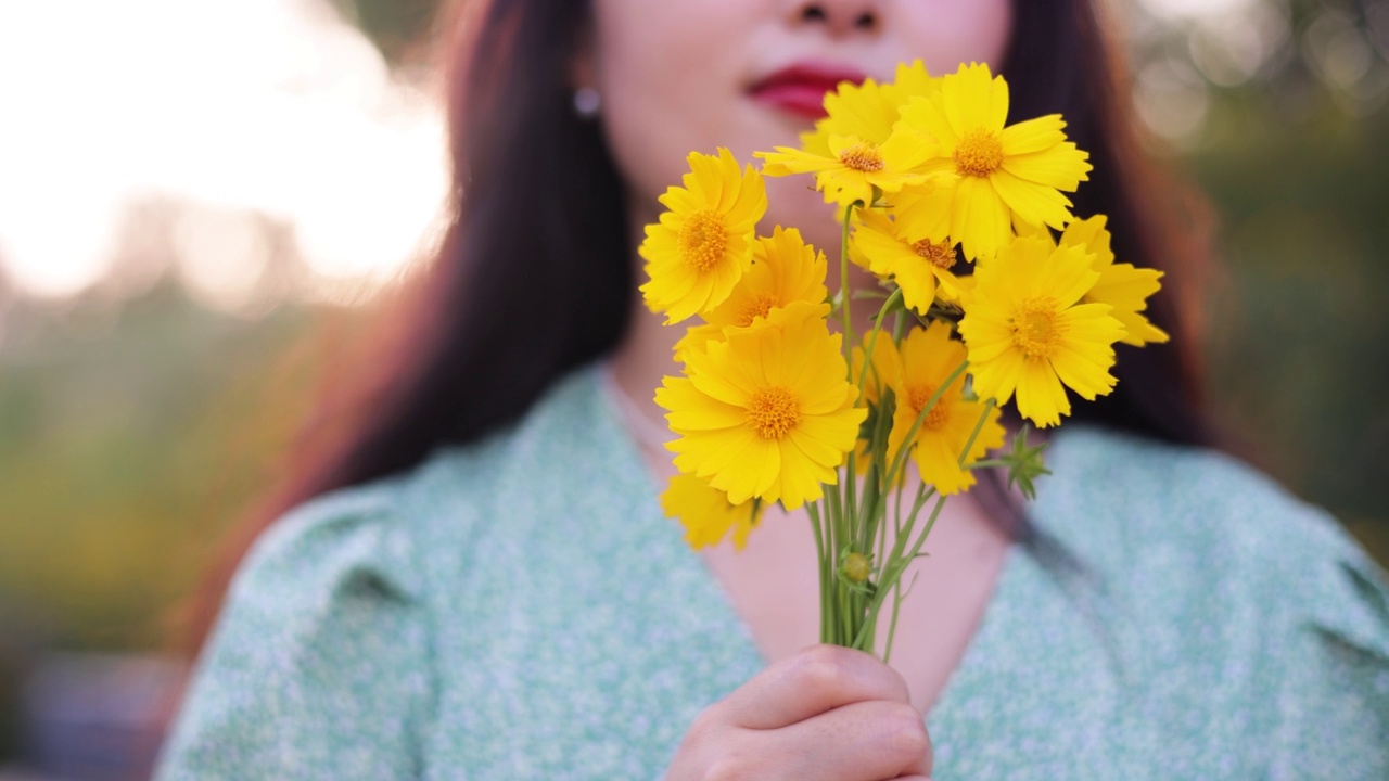 女人手里拿着黄色的花视频素材