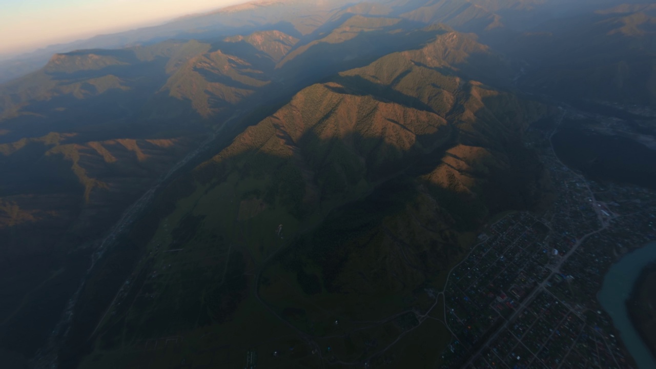 鸟瞰日落，山景，悬崖，河流，乡村，村庄，基础设施，道路，房子，屋顶视频素材