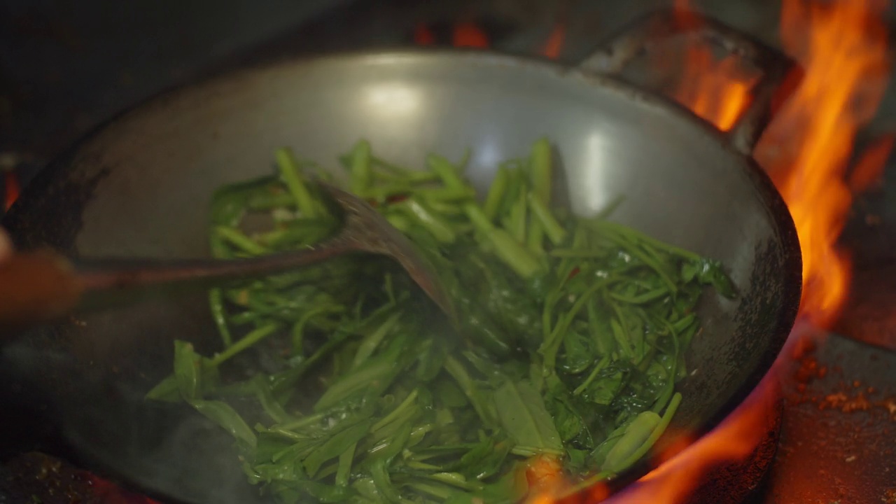 慢动作特写厨师烹饪炒锅蔬菜与食材和火焰，厨师烹饪泰国和中国风格的食物在厨房视频素材