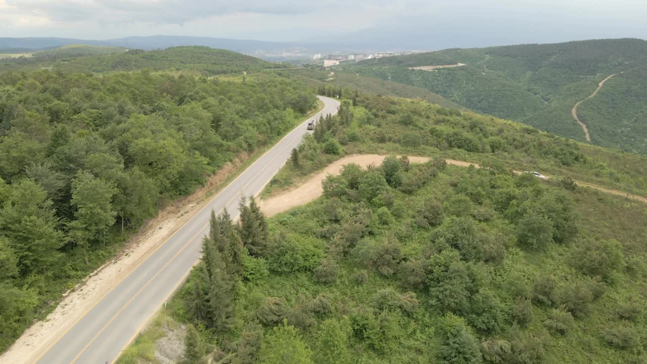 鸟瞰图，在森林道路上飞行，单辆汽车行驶视频素材