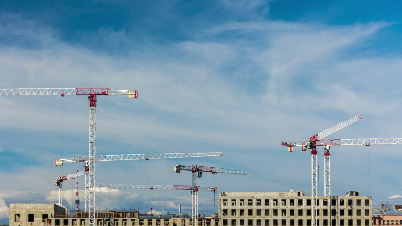 一座现代化建筑的建设，起重机在城市的建筑工地视频素材