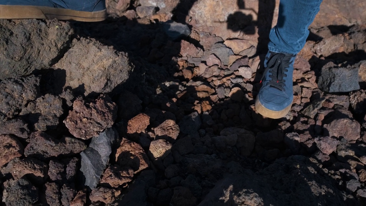 在特内里费岛的泰德火山国家公园里，一名游客走过凝固的熔岩山的特写镜头视频素材