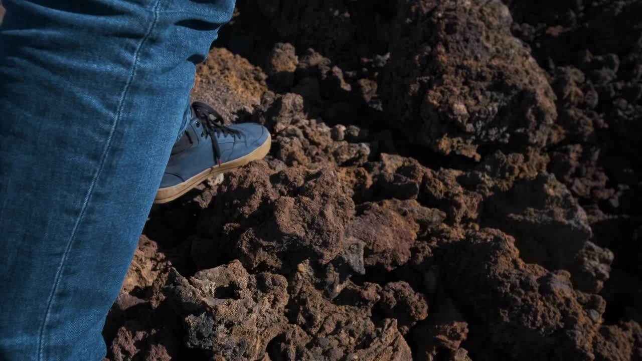 在特内里费岛的泰德火山国家公园里，一名游客走过凝固的熔岩山的特写镜头视频素材