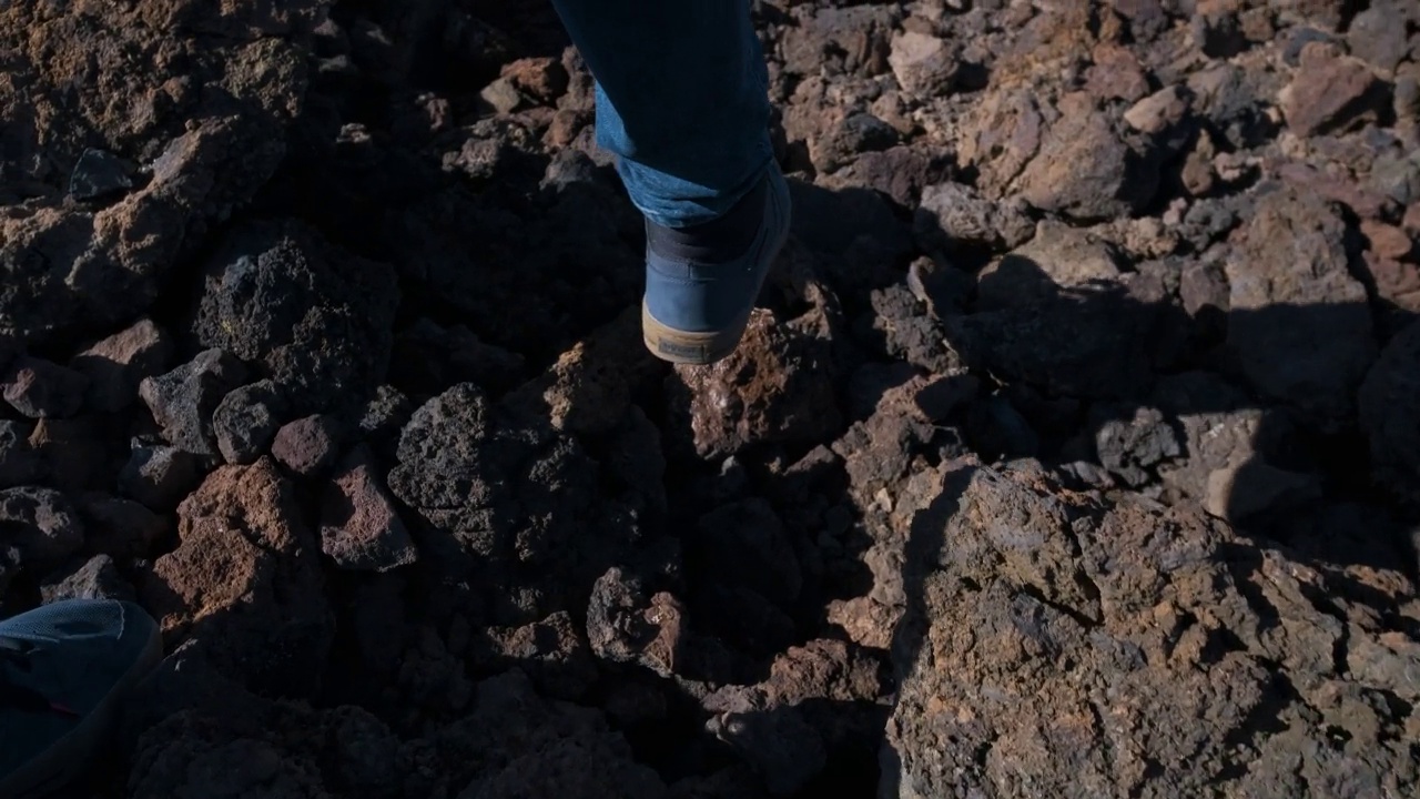 在特内里费岛的泰德火山国家公园里，一名游客走过凝固的熔岩山的特写镜头视频素材