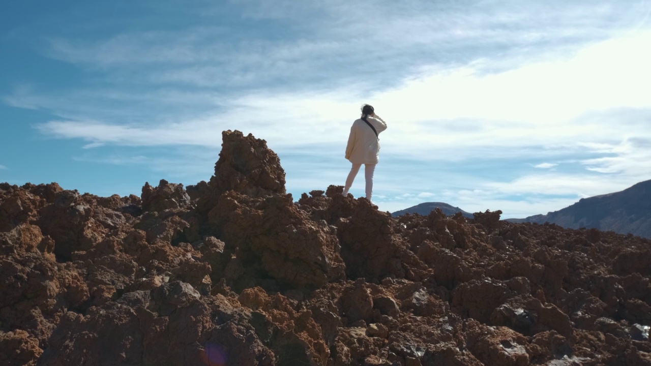 在特内里费岛的泰德火山国家公园里，一名女游客穿过凝固的熔岩山视频素材