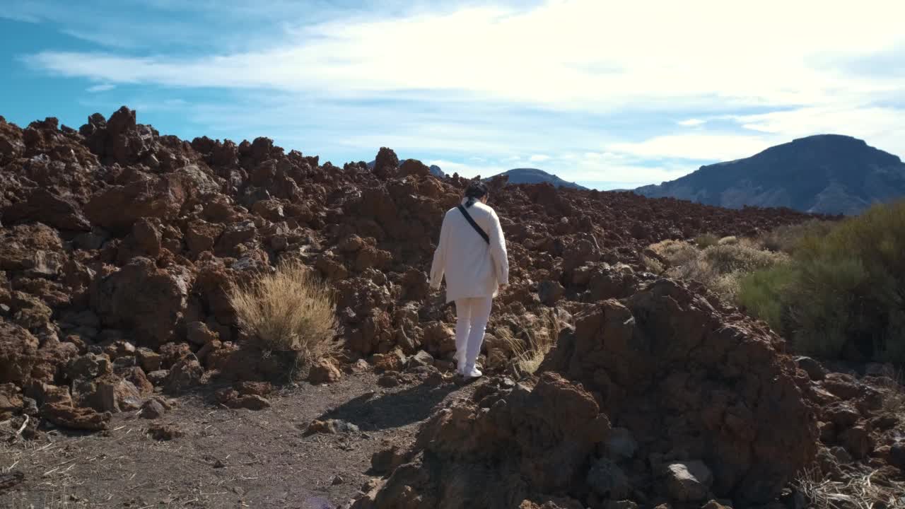 在特内里费岛的泰德火山国家公园里，一名女游客穿过凝固的熔岩山视频素材