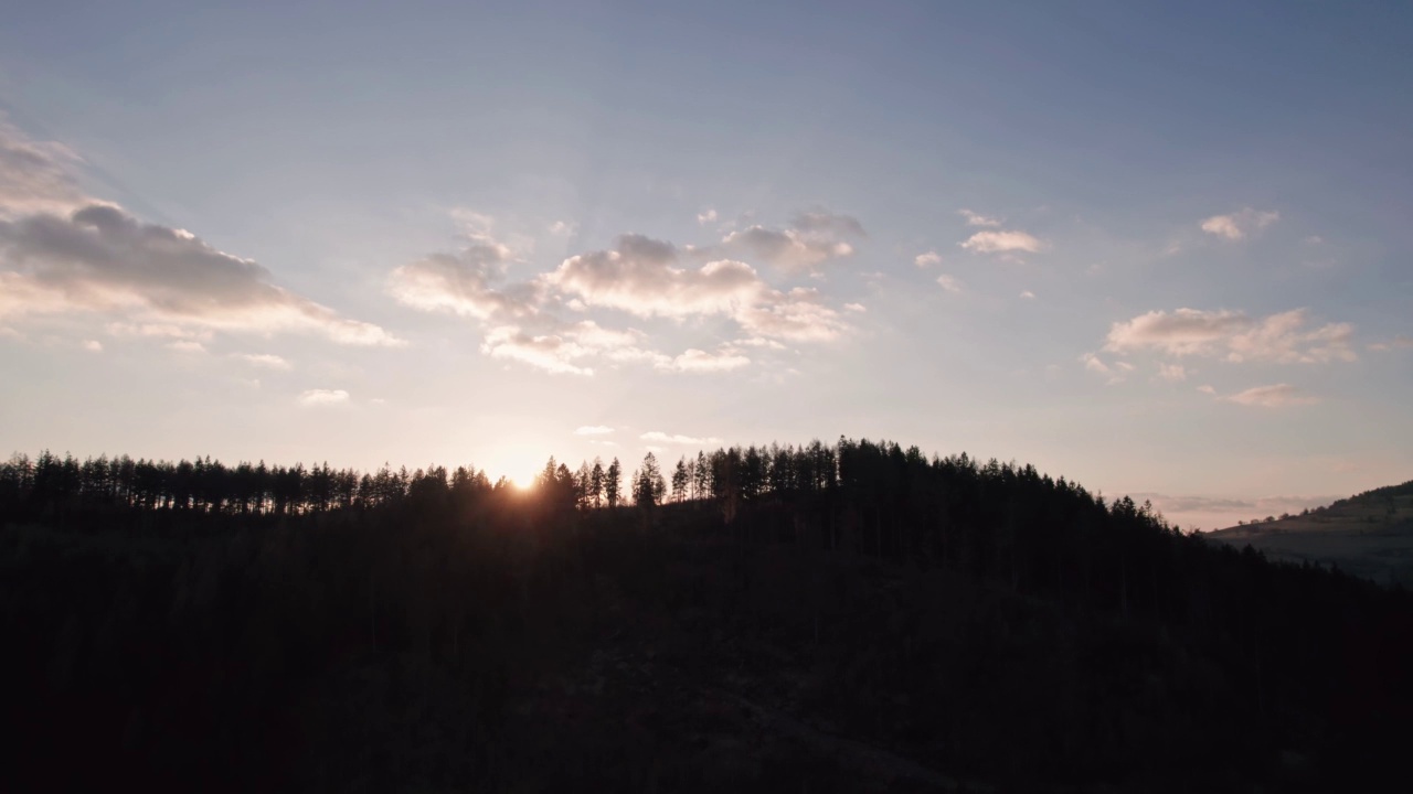 夕阳在山间小山上的树丛中闪烁着微光。魔法时刻，生态和伐木概念，停止破坏地球。视频素材