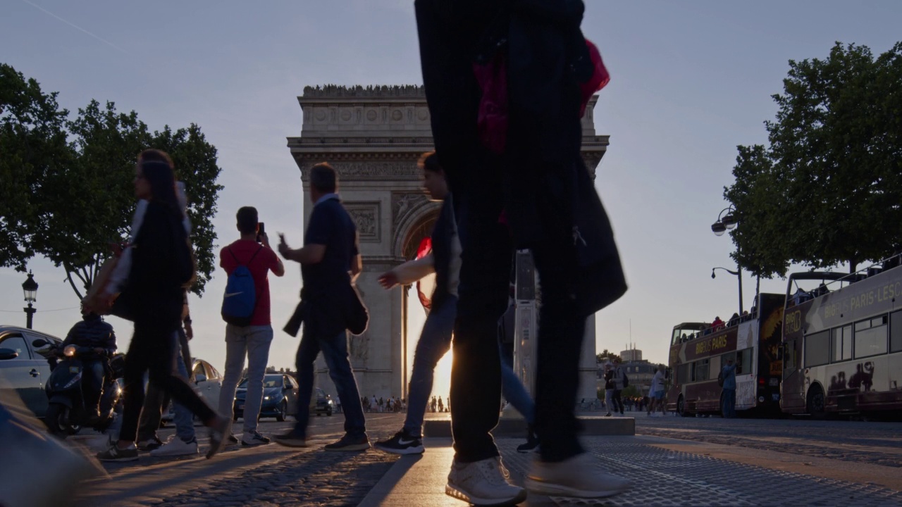 夕阳西下，慢动作的行人穿过巴黎凯旋门前的Champs Elysées大道视频下载