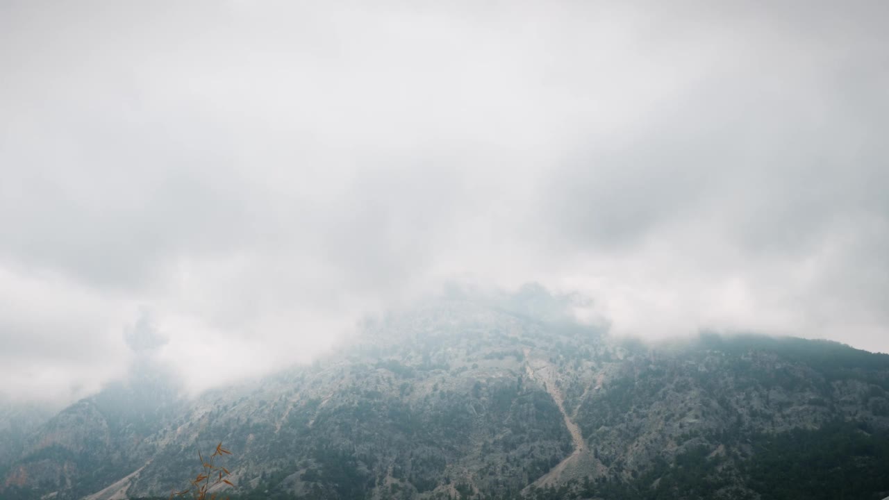 多雨的乌云笼罩着高山。云与神秘的雾在多云雨天在暴风雨雾山。雾山，时光流逝。山坡上乌云密布。野生自然景观视频素材