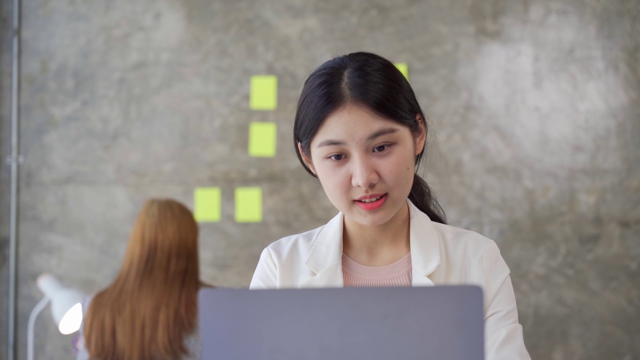 微笑的印度女大学生在笔记本电脑上打字准备课程工作学习e学习坐在书桌上检查练习本中的信息做作业研究，技术教育理念视频素材