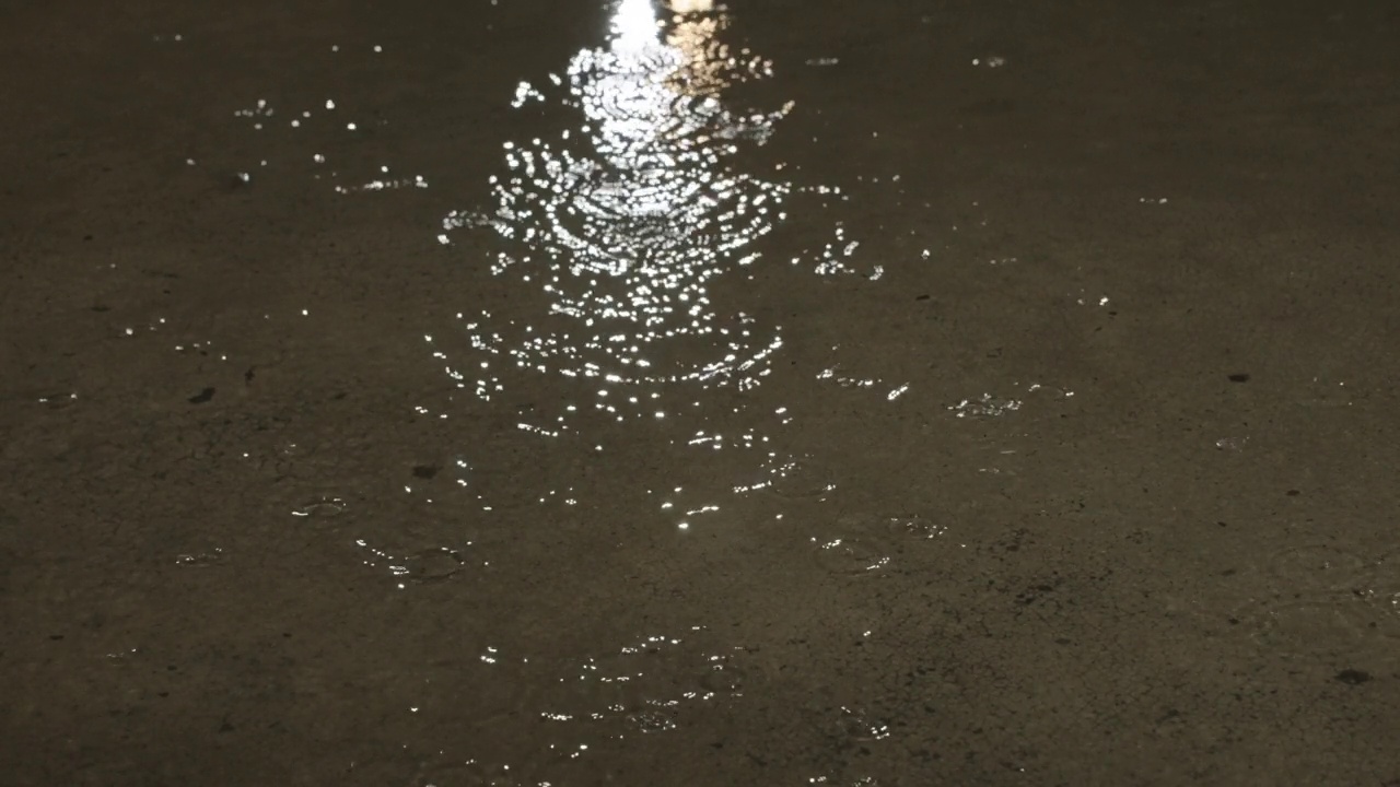 慢镜头，雨季的雨滴落在水泥地上。视频素材