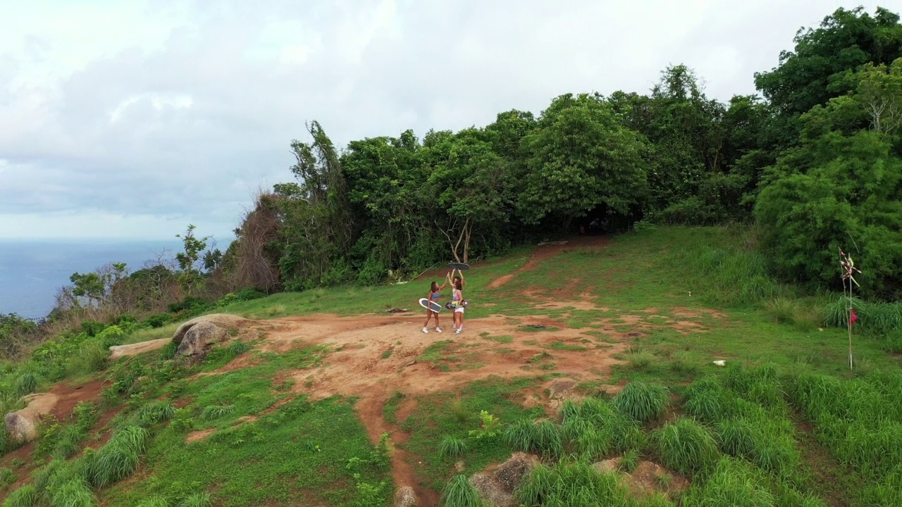 4K鸟瞰组亚洲女子暑期在热带海岛滑冰，徒步登山。视频素材