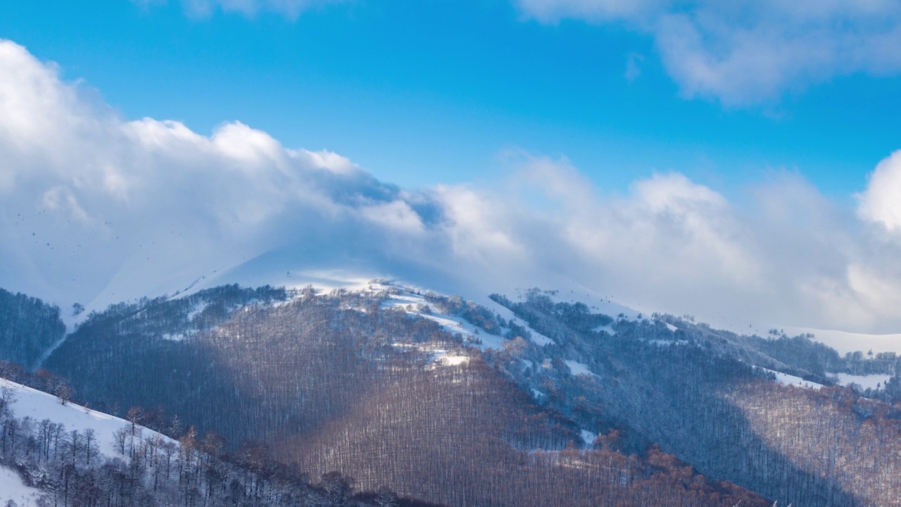 高山峻岭的风景鸟瞰。冬日阳光下的壮丽景色。蓝天，雾和雪的时间推移视频。4K背景潘拍摄的喀尔巴阡山在乌克兰视频下载