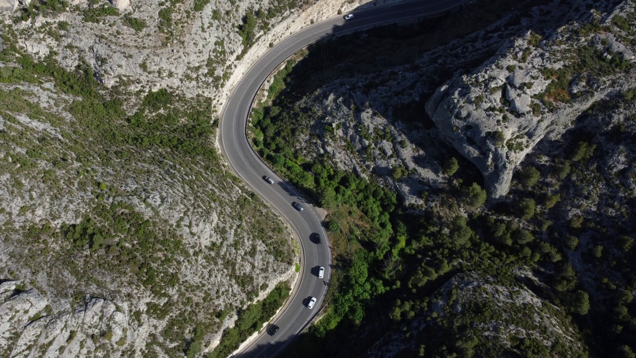 鸟瞰图，汽车和卡车行驶在弯曲的山路上。视频素材