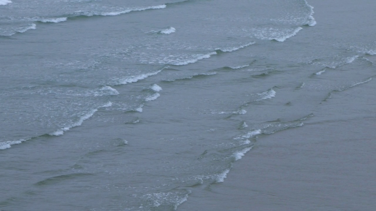 灰色的海浪，阴天的潮水。海水。手持视频。水面，全框，背景。视频素材