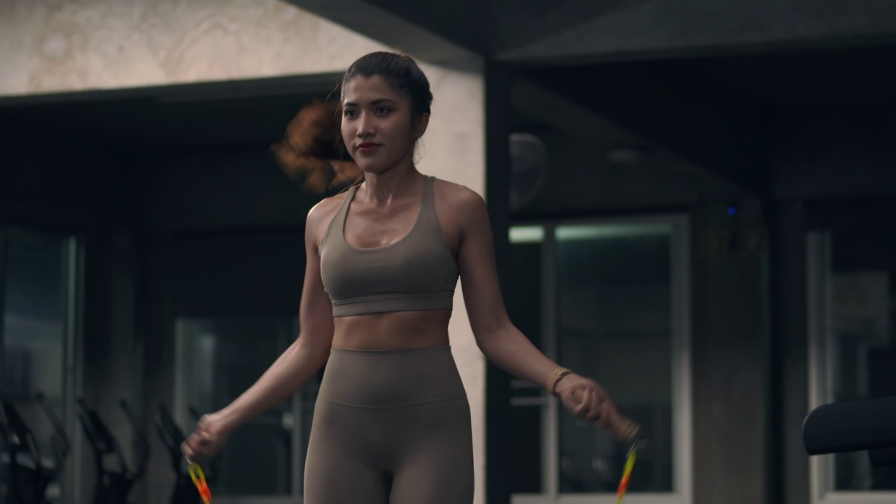 亚洲年轻的女运动员在室内跳绳，专注于有氧运动训练。视频素材