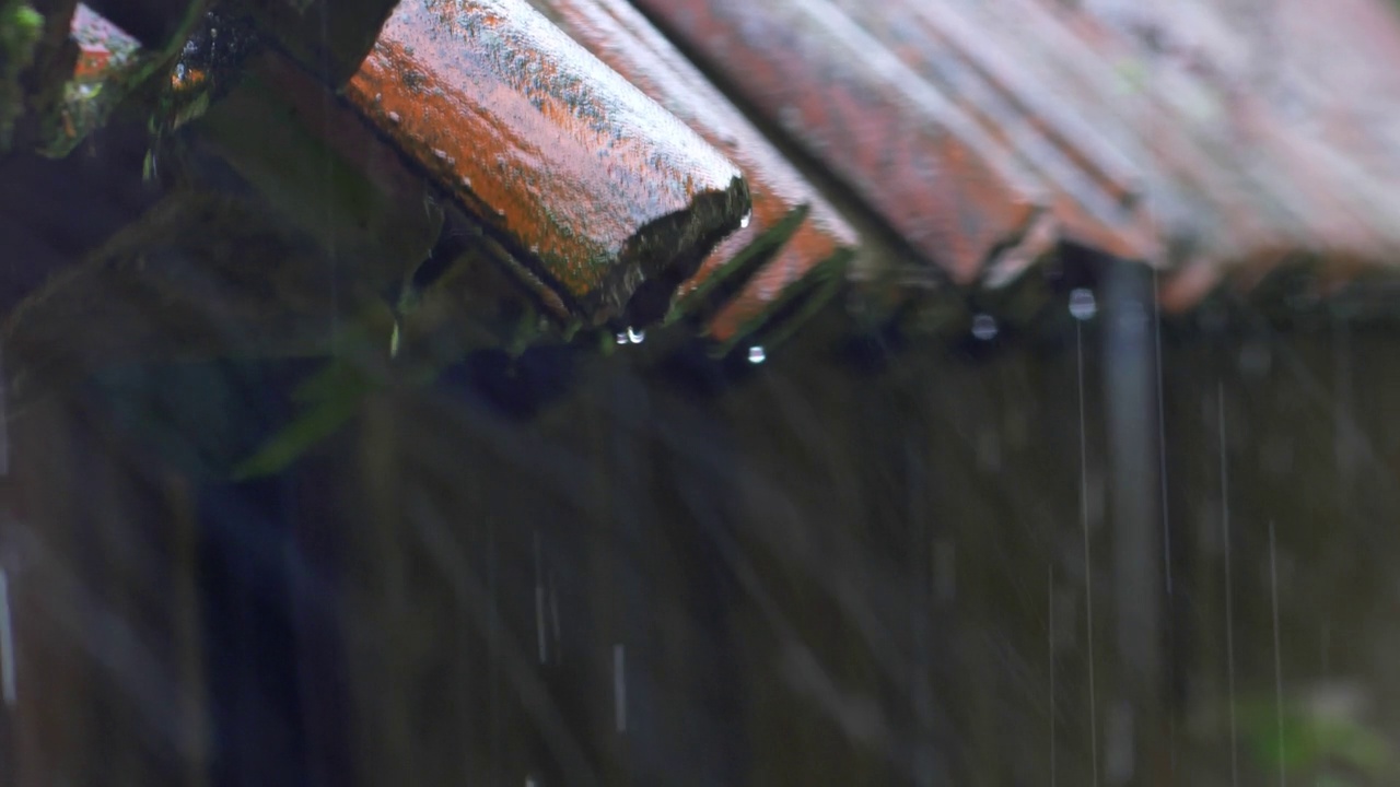 雷雨中大雨打在老房子的屋顶瓦片上视频素材