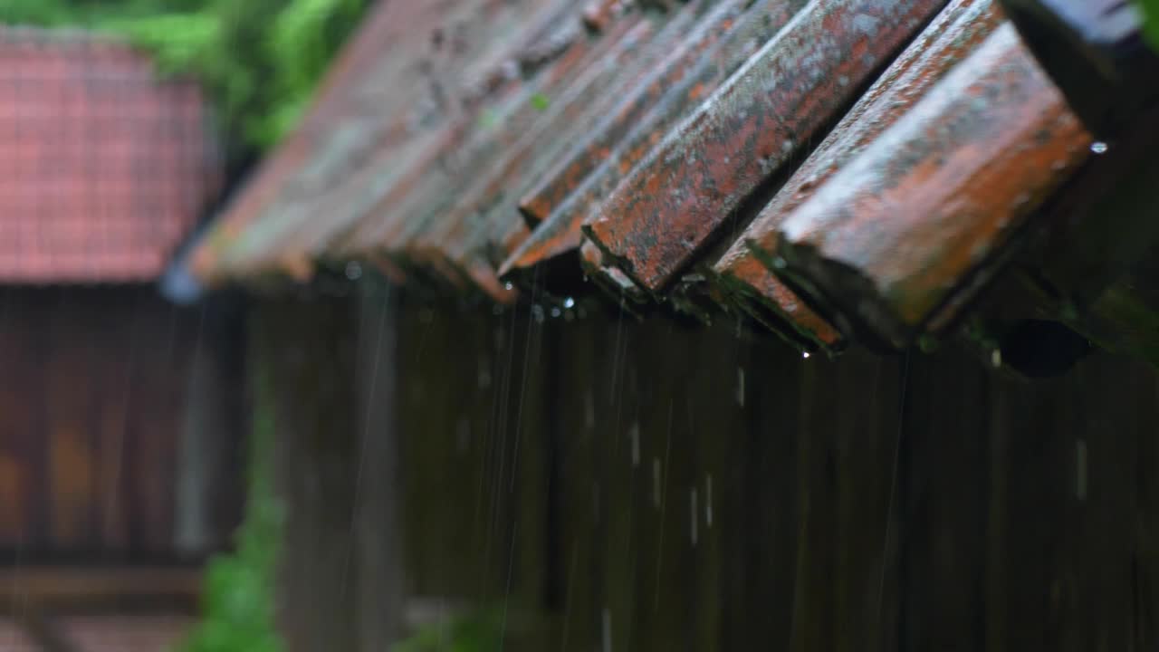 雷雨中大雨打在老房子的屋顶瓦片上视频素材