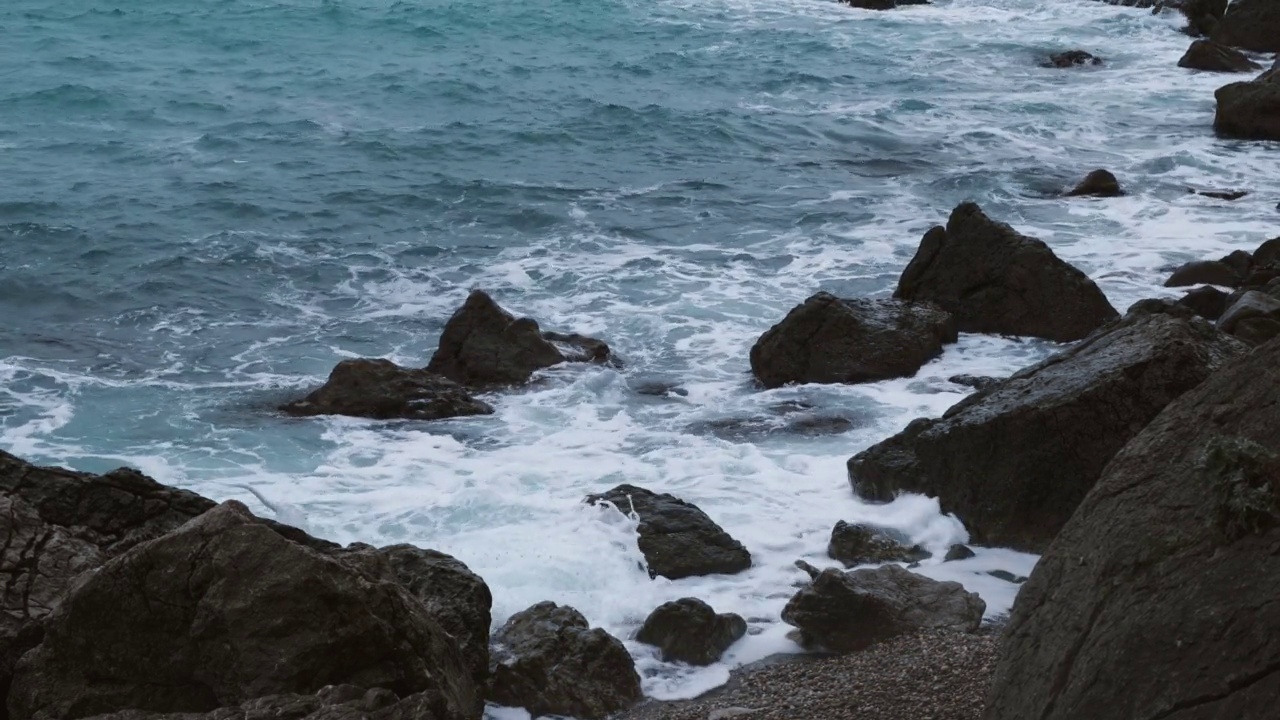 碧绿的海石沙滩，在多云的春日破浪。视频素材