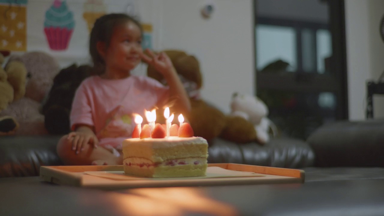 亚洲小女孩的生日，高兴和家人一起在家吹蛋糕。视频素材