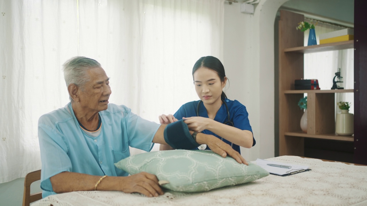 女医生上门探访老年病人，在家测量血压视频素材