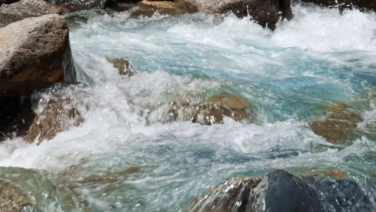 奔放的山河缓缓地流淌着清澈的河水。井水从石头上流过。森林里有充足的清流。急流附近的冷水飞溅。水背景的概念。视频素材