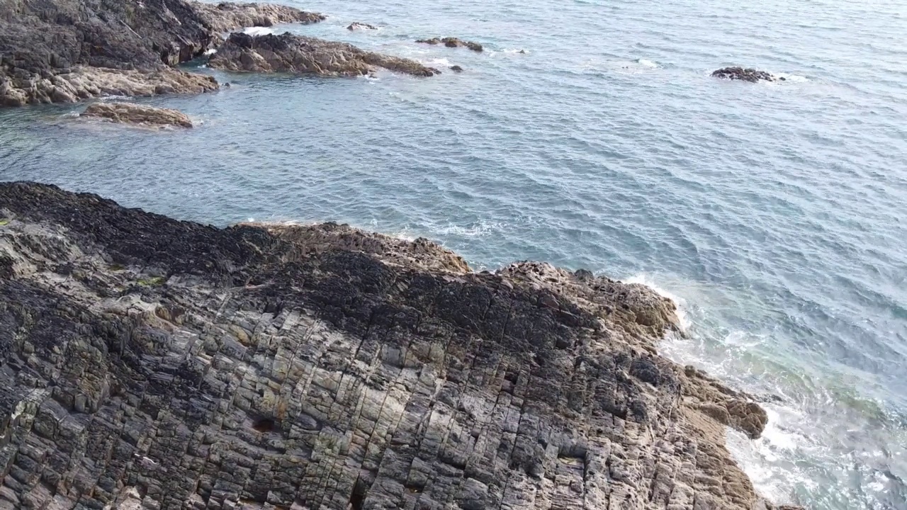 阳光明媚的日子里，海边的尖利岩石。岩石、海景。视频素材