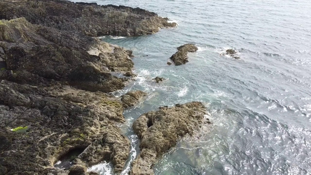 海边的岩石。地质结构。阳光照射在水面上。视频素材