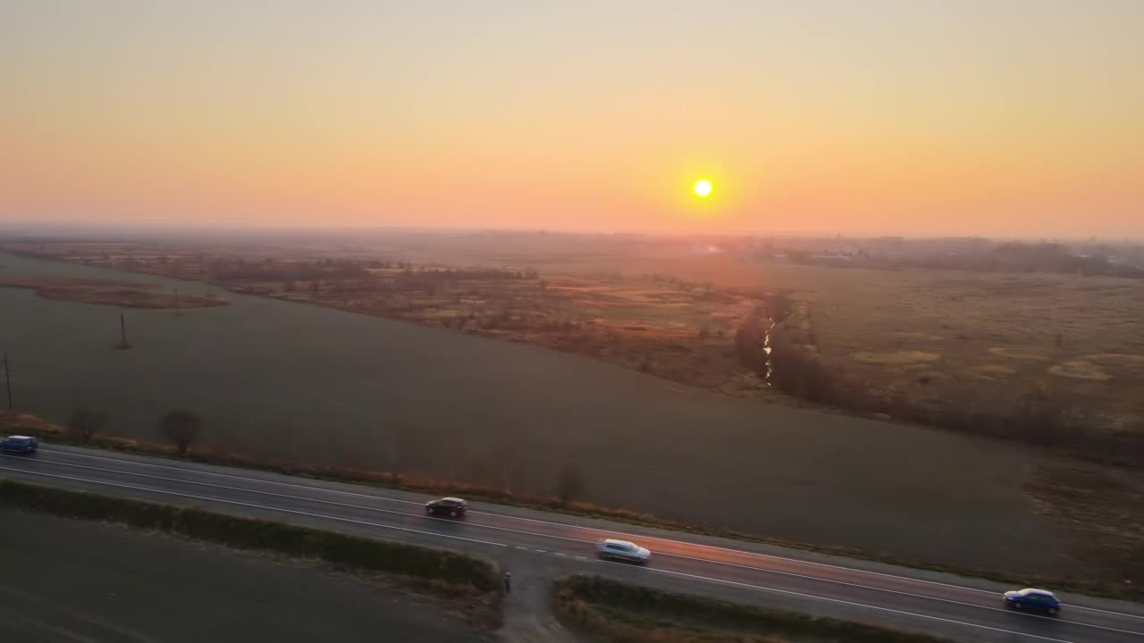 鸟瞰图城际公路与快速驾驶的汽车在日落。无人机在傍晚俯瞰公路交通视频素材