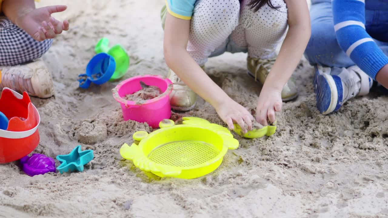 4K组多样性的小男孩和小女孩在公园的户外操场上玩沙子视频素材