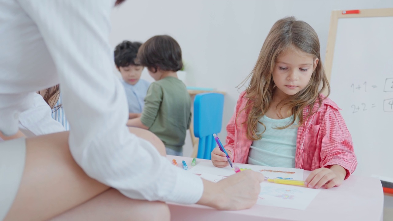 白种人美女老师在学校给孩子上课。幼稚园迷人的女教师大师在课堂上用有趣的活动讲解教育孩子们的学生。视频素材