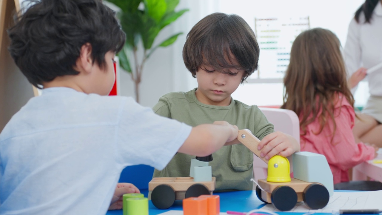 混血儿在学校一起玩耍的一群孩子。学龄前的小女孩和小男孩在幼儿园的教室里玩玩具时感到快乐和有趣。视频素材