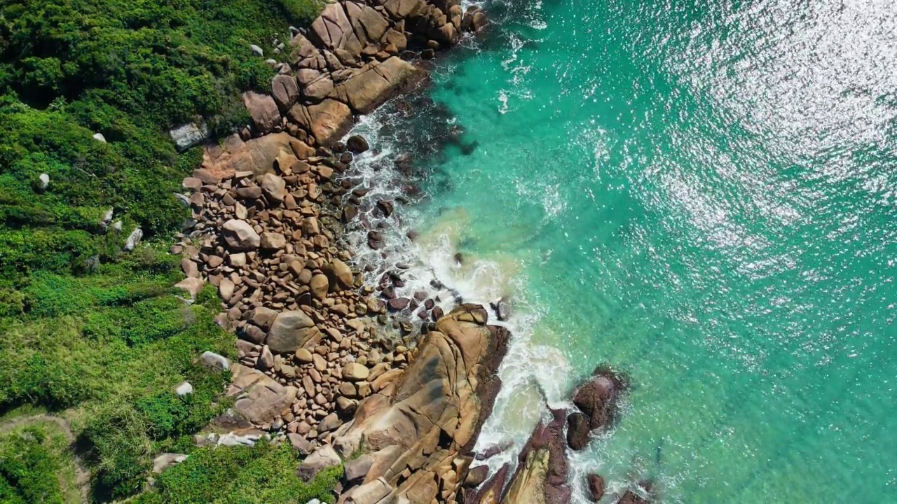 海岸线上有岩石和碧蓝透明的海浪。鸟瞰图视频素材