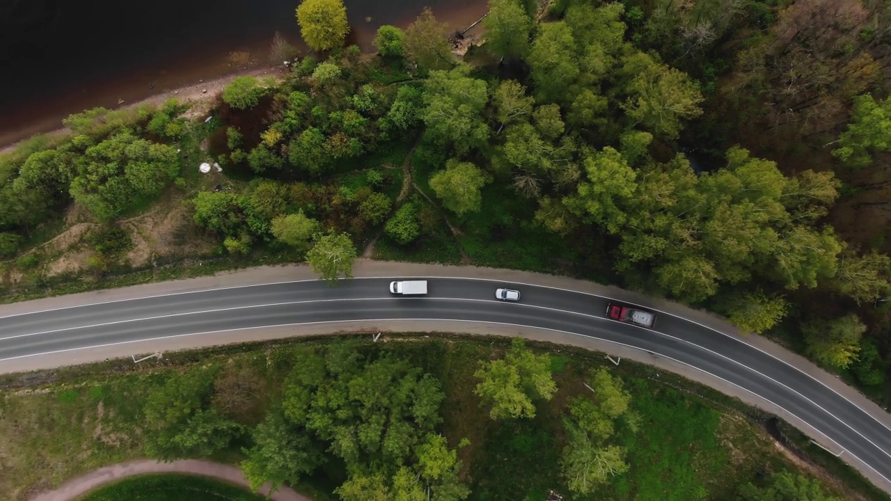 曲曲折折的双车道森林道路，树木生长在河边视频素材