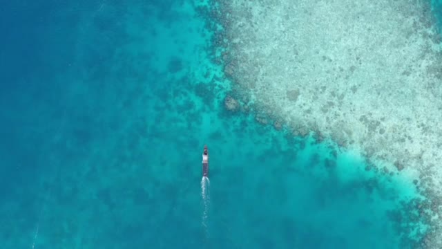 美丽清澈的海水和白色的海滩，传统的木船视频素材